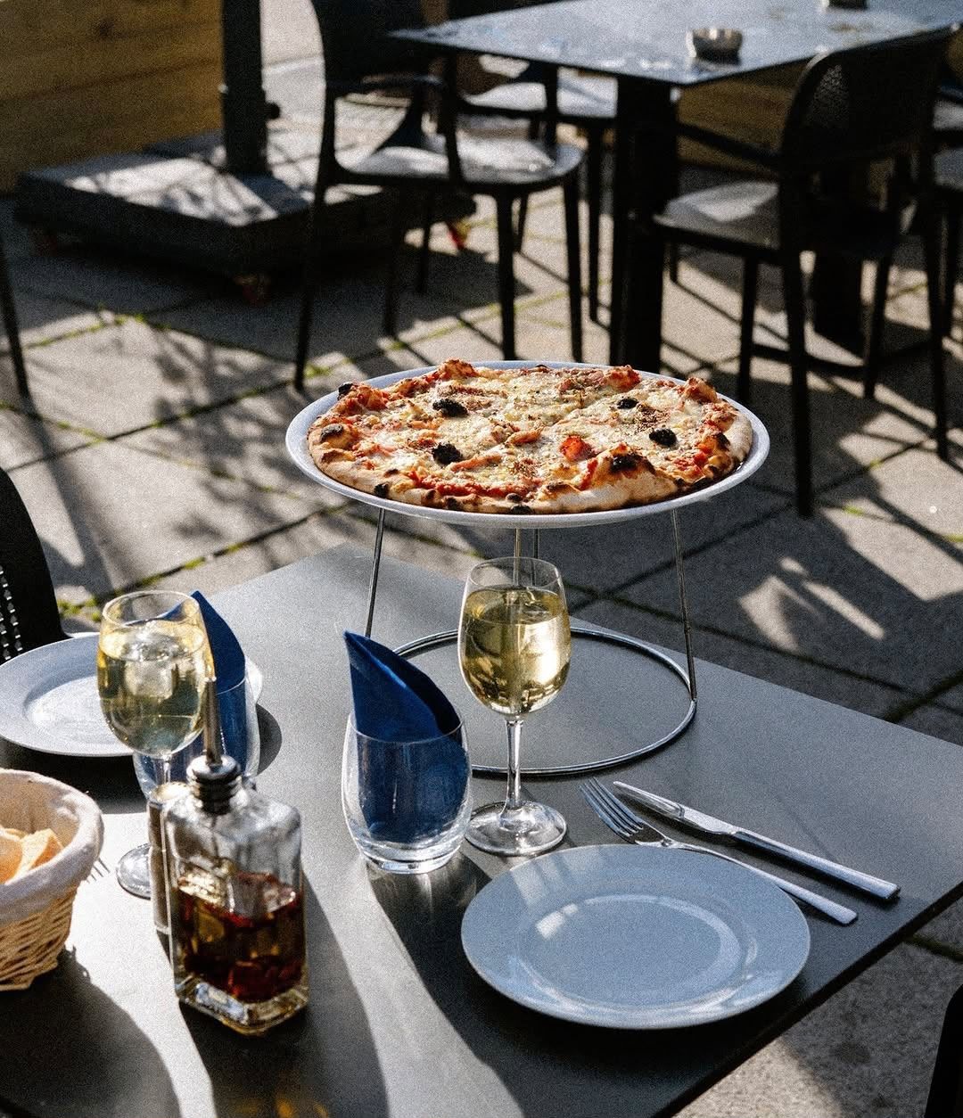 Pizza et vin blanc servis en terrasse