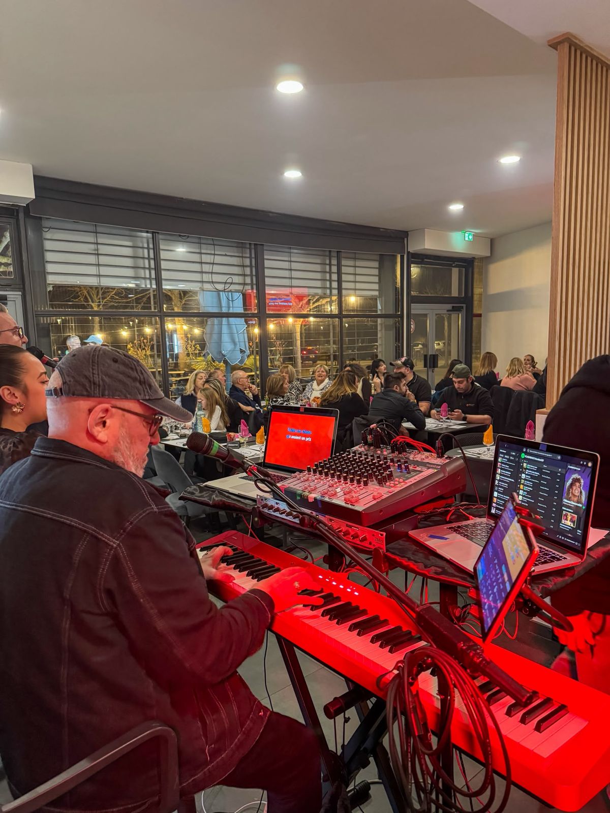 Soirée karaoké animée au Café de la Place, clavier et micros en lumière rouge